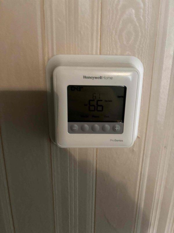 Responded to warranty service call for 5-year-old air conditioning system blowing warm air with no cooling. Performed leak search as scheduled from previous visit and conducted diagnostic testing using refrigerant manifold gauges to measure system pressures and temperatures. Found abnormal pressure readings indicating TXV malfunction affecting refrigerant flow and system performance. Documented equipment conditions with photos of diagnostic readings and thermostat displaying 86°F indoor temperature against 61°F setpoint, confirming inadequate cooling. Identified thermostatic expansion valve as failed component requiring replacement under warranty coverage. Part ordered for follow-up installation to restore proper system operation.