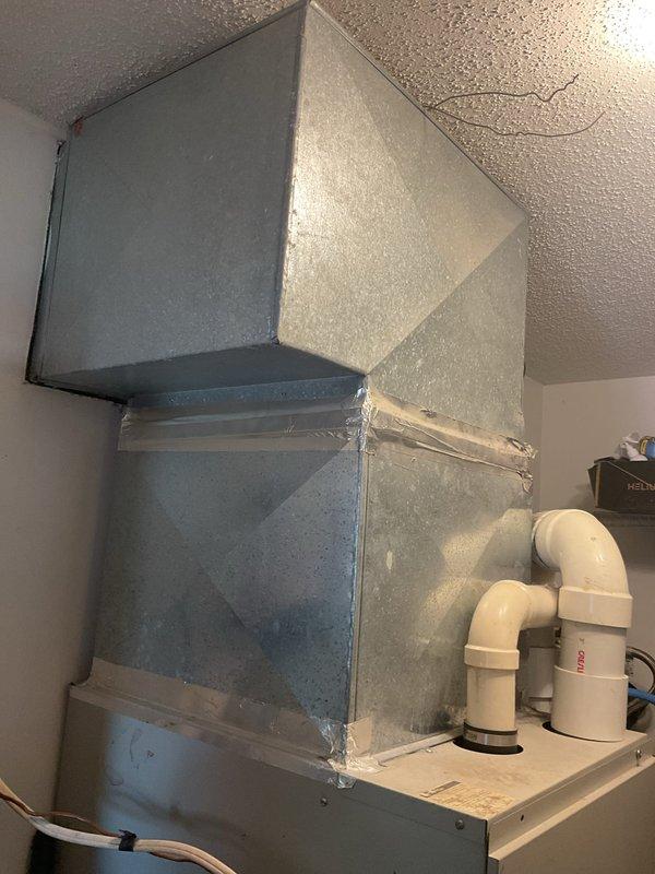 Conducted comprehensive HVAC replacement estimate for residential property experiencing system performance issues. Evaluated existing ductwork installation in mechanical area, noting gray metal rectangular duct sections with visible wear, dust accumulation, and deteriorating foil tape seals at joints. Assessed interior ventilation components including wall-mounted return air grille located adjacent to main staircase, inspected overall system configuration and documented current conditions through photographic documentation to provide accurate replacement recommendations and financing options.