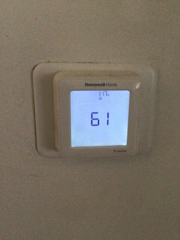 Completed annual Gold Level planned maintenance on 2-year-old HVAC system. Performed comprehensive inspection of air handler unit, evaluated Honeywell Home ProSeries thermostat operation displaying 61°F, and documented heavily soiled air filter requiring replacement due to significant dust and debris accumulation affecting system efficiency.