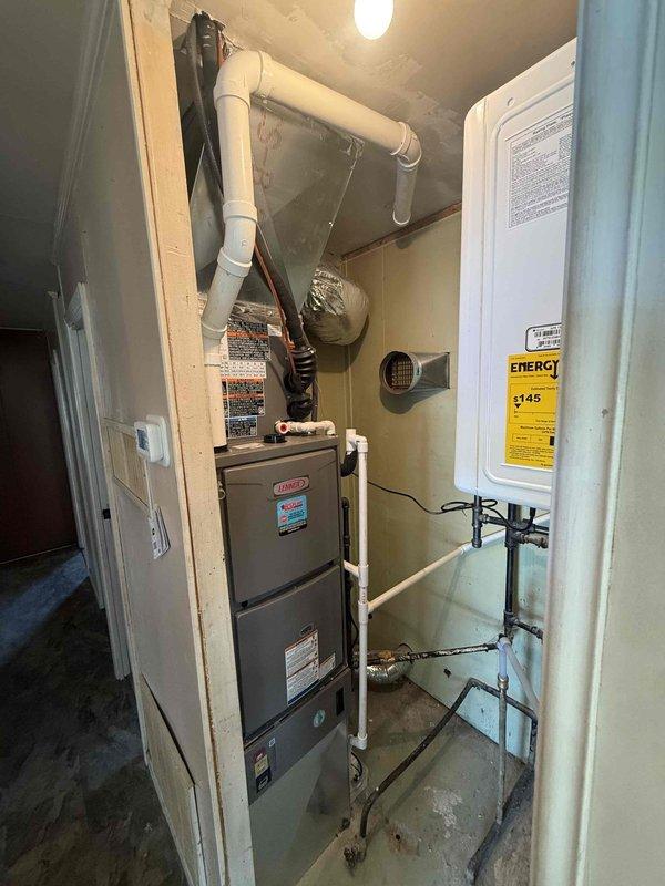 Successfully installed a 150-gallon capacity tankless water heater in residential utility closet. Completed full installation including gas line connections, water supply piping with copper and metal configurations, electrical hookup, and proper venting with white PVC exhaust system. Unit mounted securely to wall with all manufacturer specifications met and energy guide labeling in place. Installation coordinated with existing HVAC furnace system in shared mechanical room space, ensuring proper clearances and code compliance throughout.