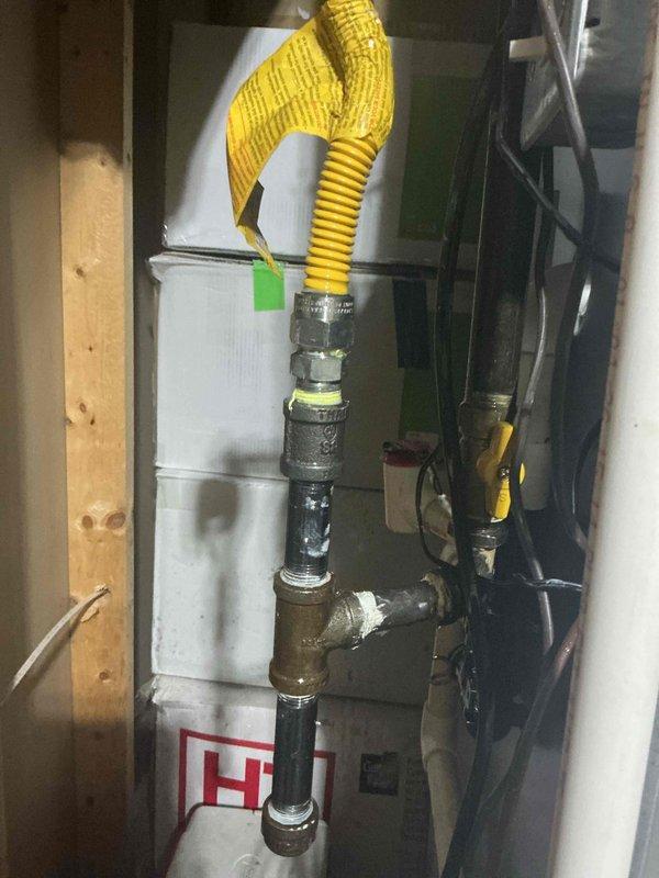 Responded to install callback for reported gas odor in basement furnace room. Upon arrival, inspected recent furnace installation and gas line connections. Located source of gas smell at flexible gas connector fitting to furnace inlet. Tightened connection at appliance connector and black iron pipe assembly, verified proper seal with leak detection solution, and confirmed no further gas odor present. System remained operational throughout service call with all components functioning properly.