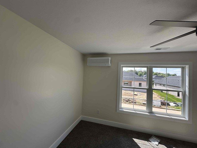 # HVAC Installation Summary

Successfully installed a 20,000 BTU dual-head ductless mini-split system at a residential property. Mounted one indoor air handler unit high on the interior wall near the ceiling in an upstairs room, positioned adjacent to a window for optimal air distribution. Installed the outdoor condenser unit on a concrete pad alongside existing HVAC equipment on the building's exterior. Ran refrigerant lines from the outdoor unit up the brick wall using white PVC line set cover for a clean, professional appearance. Connected electrical service with proper disconnect box mounted to exterior wall. System tested and confirmed operational upon completion.

# Detailed Work Performed

Completed installation of a dual-zone ductless mini-split heat pump system with 20,000 BTU capacity. The interior air handler was strategically mounted near the ceiling in a carpeted room with pale yellow walls, ensuring unobstructed airflow throughout the space. The unit placement considered 