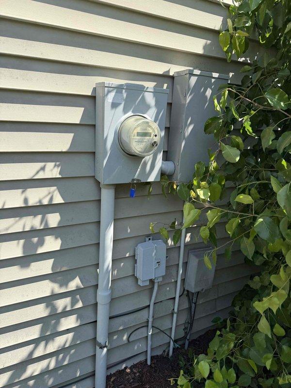 Conducted comprehensive site assessment of six buildings approximately 30 years old to develop electrical grounding estimate for lightning protection system. Property has experienced multiple lightning strikes causing power and internet service disruptions. Evaluated existing electrical service equipment including exterior meter assemblies, service panels, and conduit installations on multiple structures. Inspected current grounding configurations at main service entrances and assessed structural conditions of brick and vinyl-sided buildings. 

Documented existing electrical infrastructure through photographic survey showing analog utility meters, junction boxes, weatherproof enclosures, and exterior conduit runs. Coordinated with maintenance supervisor for facility walkthrough to identify all service entrance locations and discuss scope requirements. Assessed feasibility and routing options for underground utility line burial to mitigate future lightning damage. Prepared specification
