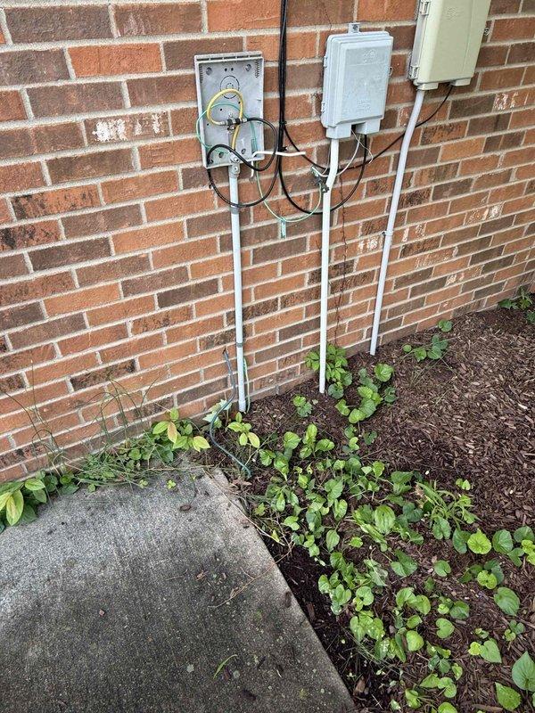 Conducted comprehensive site assessment of six buildings approximately 30 years old to develop electrical grounding estimate for lightning protection system. Property has experienced multiple lightning strikes causing power and internet service disruptions. Evaluated existing electrical service equipment including exterior meter assemblies, service panels, and conduit installations on multiple structures. Inspected current grounding configurations at main service entrances and assessed structural conditions of brick and vinyl-sided buildings. 

Documented existing electrical infrastructure through photographic survey showing analog utility meters, junction boxes, weatherproof enclosures, and exterior conduit runs. Coordinated with maintenance supervisor for facility walkthrough to identify all service entrance locations and discuss scope requirements. Assessed feasibility and routing options for underground utility line burial to mitigate future lightning damage. Prepared specification