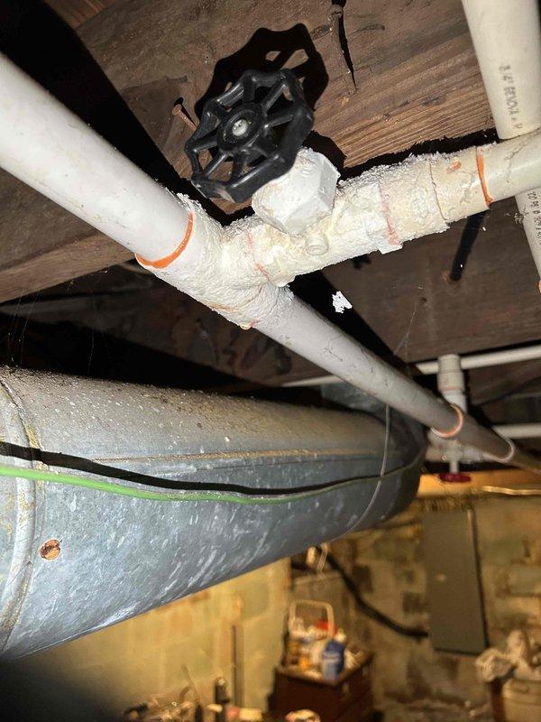 Completed annual Platinum Level maintenance on a 5-year-old HVAC system, including replacement of 20x25x5 filter and comprehensive inspection of all components. Identified deteriorated PVC coupling at base of condensate drain line with visible cracking and material breakdown requiring attention. Documented plumbing infrastructure including shut-off valves, insulated piping, and drain pan positioning for system monitoring.