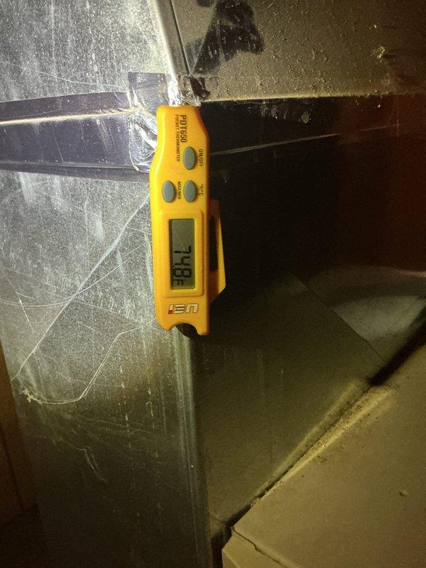 Responded to follow-up service call for incomplete HVAC work requiring system charging and furnace door switch replacement. Upon arrival, performed diagnostic temperature measurements on evaporator coil assembly using digital thermometer, recording supply air temperature of 53.6°F at the coil outlet. Documented current system operating conditions with thermal imaging to establish baseline performance metrics. Confirmed refrigerant charge is needed to achieve proper cooling capacity. Inspected furnace cabinet and verified door safety switch remains bypassed from previous service due to broken switch assembly. Photographed equipment conditions and measurement readings for service documentation. System requires return visit to complete refrigerant charging to manufacturer specifications and install replacement door interlock switch to restore proper safety controls on furnace unit.