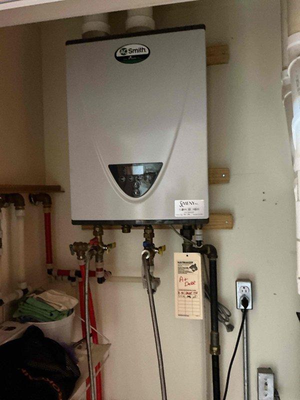 # Plumbing Maintenance - Tankless Water Heater Flush

Performed routine maintenance flush on wall-mounted A.O. Smith tankless water heater unit. Completed descaling procedure by connecting flush pump to service valves, circulating descaling solution through heat exchanger to remove mineral buildup and scale deposits. Inspected all plumbing connections, brass valves, and PEX tubing for proper operation. Verified unit functionality post-flush, checked digital display panel for error codes, and confirmed proper water flow through system. Unit returned to normal operation with improved efficiency.