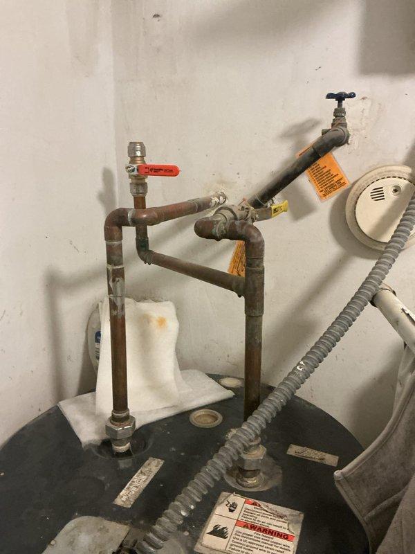 Responded to water leak reported above water heater in utility closet. Upon inspection, identified failed expansion tank with active leak at connection point on vertical copper supply line. Existing 2-gallon expansion tank showed significant corrosion and deterioration at threaded connection, causing water discharge onto surrounding piping and drain pan. Documented condition of corroded copper piping throughout assembly and noted multiple aged connections with heavy patina buildup. 

Ordered replacement 2-gallon expansion tank with female 3/4" pro press copper adapter for installation. System remains operational with water supply active. Scheduled follow-up installation appointment for next day upon part delivery. Estimated repair time of 45 minutes for tank replacement and connection. Advised customer of repair plan and timeline for completion.