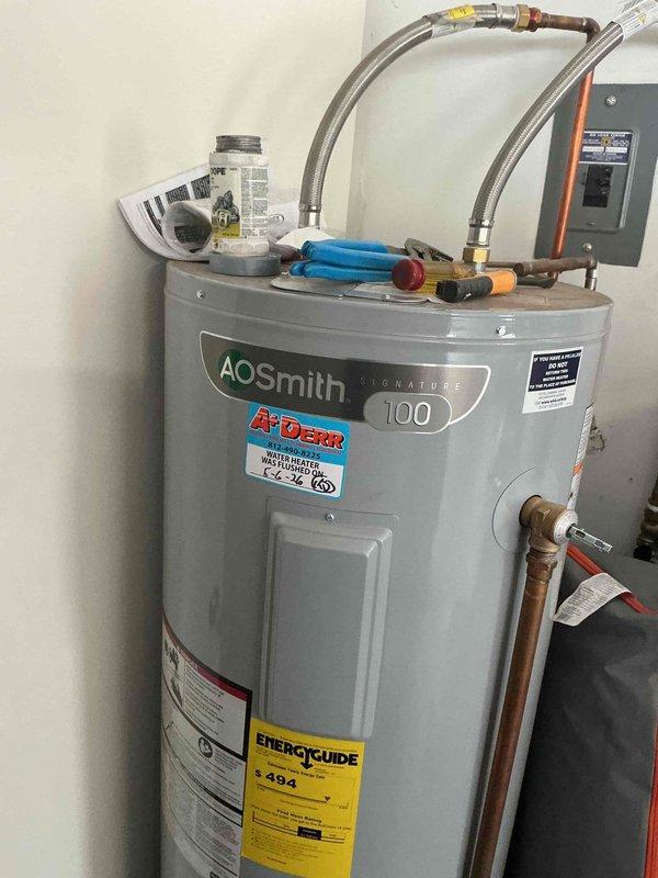 Completed routine tanked water heater maintenance flush on a 2-year-old AO Smith Signature 100 residential unit as part of the USA Bronze maintenance plan. Performed standard drain and flush procedure to remove sediment buildup from the tank bottom, inspected all connection points including braided supply lines and copper piping for proper operation, and affixed service completion sticker documenting the maintenance date. Unit operating within normal parameters with no leaks or deficiencies noted upon completion.