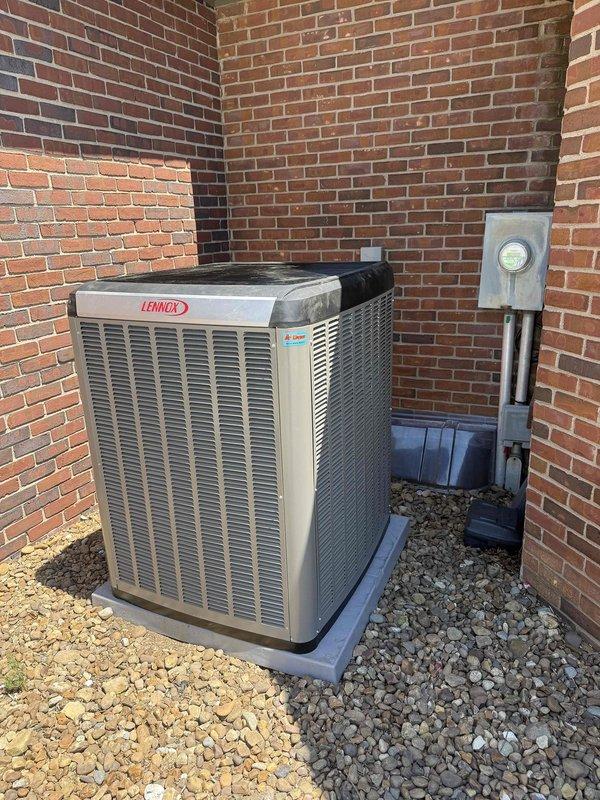 Completed installation of a 4-ton, 22 SEER Lennox heat pump system in Boonville. The outdoor condensing unit was mounted on a composite pad in a corner area with proper clearances from brick walls, and the indoor air handler was installed in the basement mechanical room alongside existing ductwork. All electrical connections, refrigerant lines, and condensate drainage were properly configured, and the system was tested for proper operation upon completion.