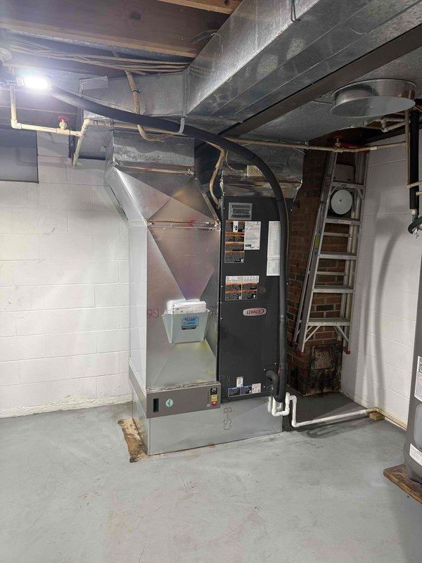 Completed installation of a 4-ton, 22 SEER Lennox heat pump system in Boonville. The outdoor condensing unit was mounted on a composite pad in a corner area with proper clearances from brick walls, and the indoor air handler was installed in the basement mechanical room alongside existing ductwork. All electrical connections, refrigerant lines, and condensate drainage were properly configured, and the system was tested for proper operation upon completion.