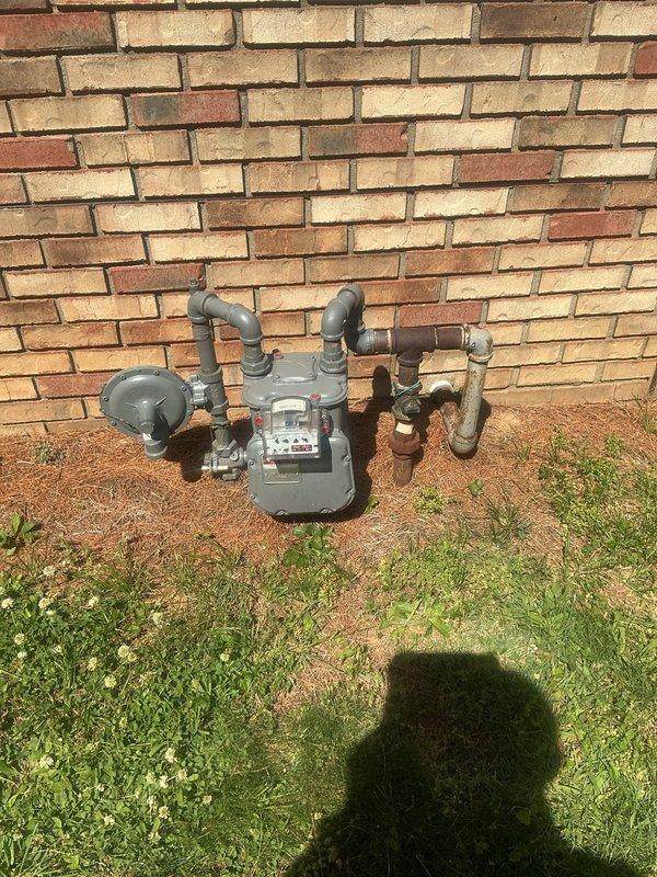 Responded to gas odor complaint originating from fireplace area with occasional smell reported. Conducted comprehensive gas leak inspection of natural gas meter, exterior piping connections, water heater gas supply lines, and fireplace gas valve assembly. Performed leak detection testing using combustible gas detector at all accessible gas connections, joints, and fittings. Inspected water heater gas flex connector, brass fittings, and shut-off valve for integrity and proper installation. Verified gas meter connections and exterior piping showed no signs of leakage following recent utility company meter replacement work. Examined fireplace gas log system and associated gas valve components for potential leak sources. All testing confirmed no active gas leaks detected at time of inspection. System deemed safe for operation with gas supply restored.