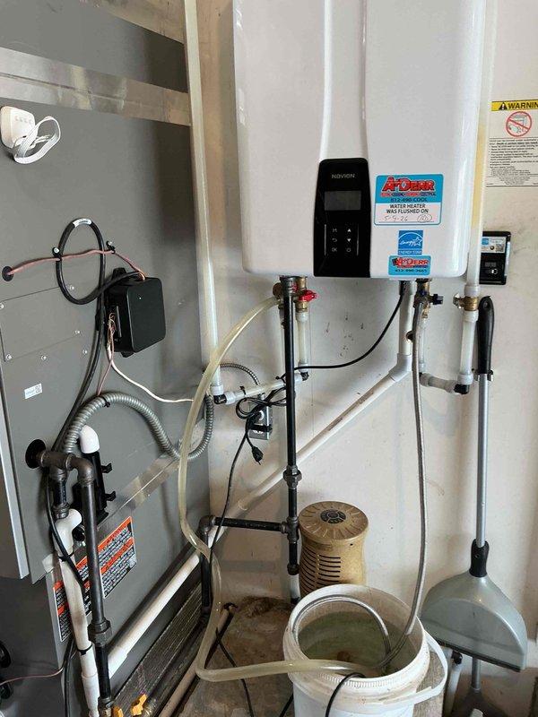 Completed scheduled tankless water heater maintenance flush as part of Bronze Plan service agreement at no additional charge to customer. Performed descaling procedure on wall-mounted tankless unit, flushing system with appropriate cleaning solution to remove mineral buildup and maintain optimal heat exchanger efficiency. Inspected all inlet and outlet connections, shut-off valves, and flexible supply lines for proper operation and signs of wear. Verified digital control panel functionality and confirmed unit operating within normal parameters. Documented installation condition with photographs showing proper venting, plumbing connections, and overall system integrity.