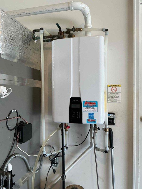 Completed scheduled tankless water heater maintenance flush as part of Bronze Plan service agreement at no additional charge to customer. Performed descaling procedure on wall-mounted tankless unit, flushing system with appropriate cleaning solution to remove mineral buildup and maintain optimal heat exchanger efficiency. Inspected all inlet and outlet connections, shut-off valves, and flexible supply lines for proper operation and signs of wear. Verified digital control panel functionality and confirmed unit operating within normal parameters. Documented installation condition with photographs showing proper venting, plumbing connections, and overall system integrity.