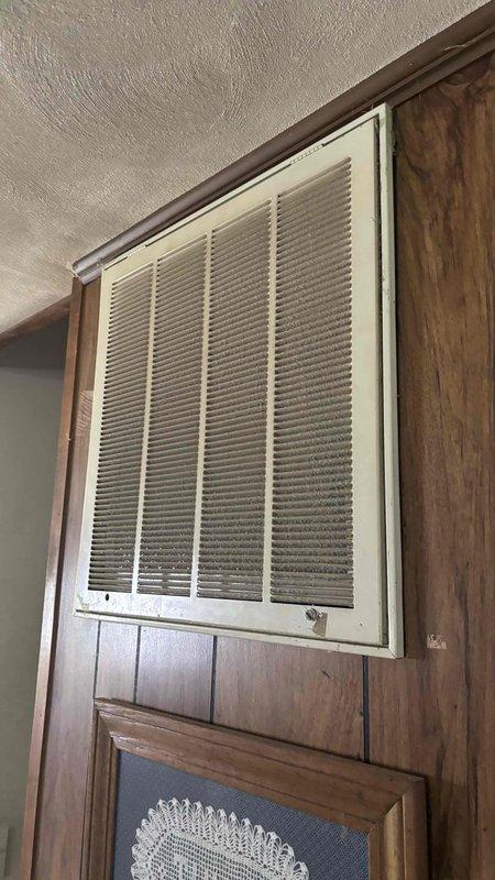 Conducted comprehensive HVAC system evaluation for complete replacement estimate, including assessment of existing ductwork conditions in crawl space and return air system. Inspected underfloor infrastructure revealing aged ductwork, electrical components, and structural considerations for new system installation. Evaluated interior return air grille and ventilation pathways to determine requirements for complete system replacement and duct cleaning services, providing customer with options for full HVAC system upgrade and ductwork remediation.