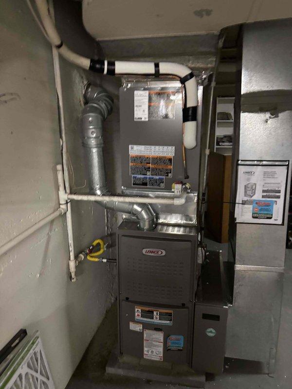 Installed a complete 2.5-ton Lennox air conditioning system including indoor evaporator coil integrated with existing furnace and outdoor condensing unit. The outdoor unit was positioned on a rubber isolation pad against the building's brick exterior with proper electrical disconnect and refrigerant line connections via PVC-concealed penetrations. All work was completed under permit RES-HVAC-26-03197 with proper refrigerant charging, system testing, and verification of airflow through existing ductwork infrastructure.