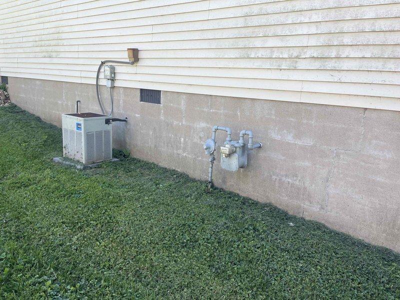 Completed comprehensive HVAC system replacement estimate for a small to mid-sized residential property (1001-1599 sq. ft.) requiring both heating and cooling components. Evaluated existing natural gas furnace located in crawl space with deteriorating ductwork and outdoor condensing unit mounted on foundation with weathered electrical connections. Assessed installation requirements including vapor barrier conditions, structural access limitations in confined crawl space, existing gas line configuration with shut-off valve, and electrical service routing to outdoor unit.