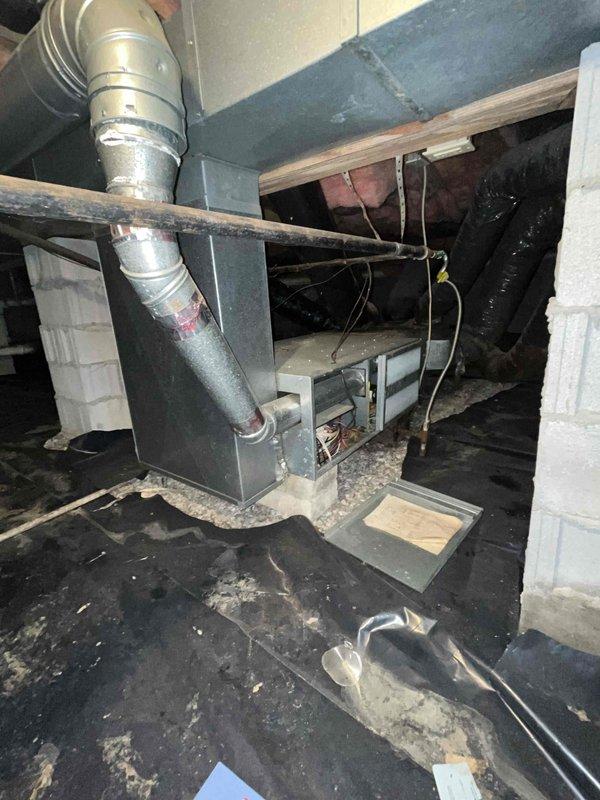 Completed comprehensive HVAC system replacement estimate for a small to mid-sized residential property (1001-1599 sq. ft.) requiring both heating and cooling components. Evaluated existing natural gas furnace located in crawl space with deteriorating ductwork and outdoor condensing unit mounted on foundation with weathered electrical connections. Assessed installation requirements including vapor barrier conditions, structural access limitations in confined crawl space, existing gas line configuration with shut-off valve, and electrical service routing to outdoor unit.