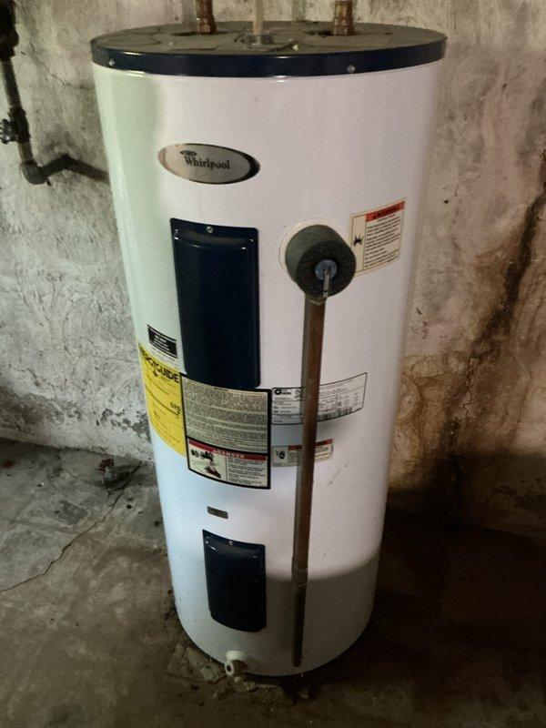 Performed routine maintenance flush on Whirlpool tanked water heater previously installed in basement utility area. Drained sediment buildup from tank bottom through drain valve, inspected temperature and pressure relief valve discharge piping, and verified all connections and access panels were properly secured. Unit returned to normal operation with improved efficiency.