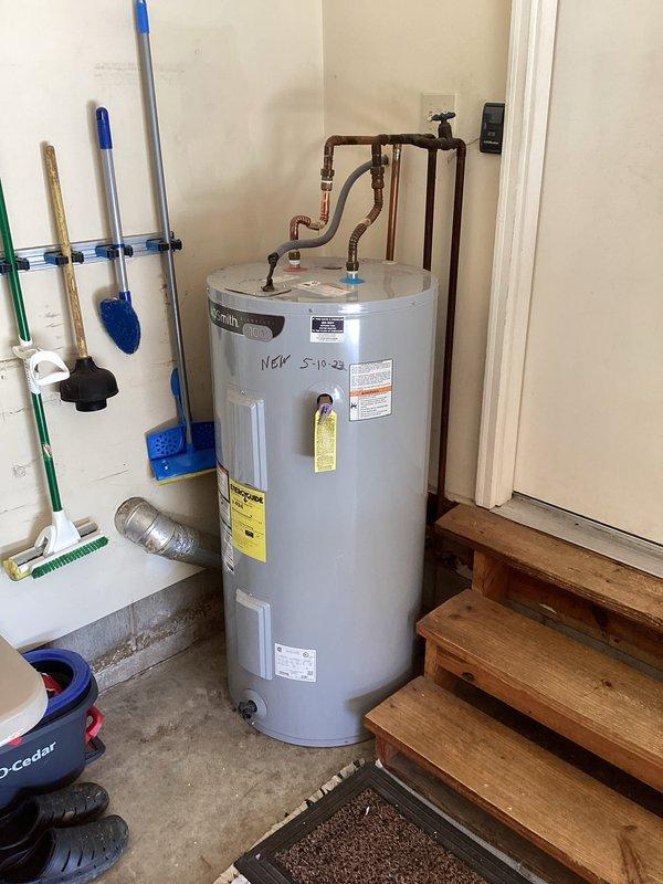 # Plumbing Maintenance - Tanked Water Heater Flush - A+

Performed routine maintenance flush on an AO Smith tanked water heater to remove sediment buildup and ensure optimal performance. The unit, installed in 2023, showed normal operating conditions with all safety labels and specifications clearly visible. Connected copper supply lines, shut-off valve, and pressure relief valve were inspected and found to be in proper working order.

Executed complete tank flush procedure by connecting drain hose to the drain valve at the base of the unit and thoroughly evacuating accumulated sediment from the tank bottom. Allowed water to run clear to ensure complete removal of mineral deposits and debris that can reduce heating efficiency and tank longevity. Verified proper drainage and checked for any signs of corrosion or leaks around the tank body and connection points.

Inspected all plumbing connections at the top of the unit, including hot water outlet and cold water inlet lines with associat