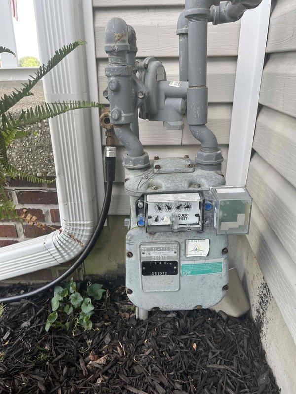 Conducted comprehensive replacement estimate for 27-year-old original HVAC system with uncertain operational status. Evaluated existing outdoor condenser unit positioned on concrete pad near residential structure, assessed electrical disconnect and meter configuration, and documented gas meter assembly for system compatibility requirements. Provided homeowner with complete replacement options and specifications for aging equipment approaching end of service life.