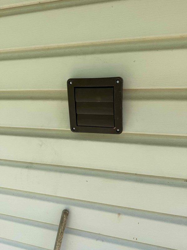 Installed new exterior dryer vent termination on building exterior wall with brown louvered vent cover, properly secured to vinyl siding. Routed and connected metallic ductwork from laundry room dryer to exterior termination point, ensuring proper airflow and code-compliant installation.