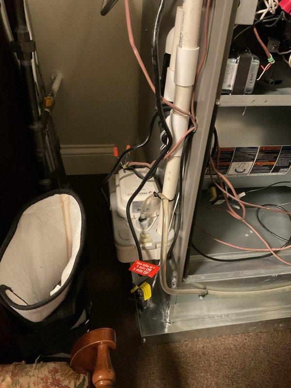 Responded to no cooling complaint on 7-month-old system blowing room temperature air with 12-degree temperature differential between setpoint and actual room temperature. Performed diagnostic evaluation of recently installed HVAC system including inspection of outdoor condensing unit, indoor air handler, refrigerant lines, and electrical connections. Verified proper airflow through vents with no ice buildup present at indoor coil, confirmed system operational status, and documented installation configuration with outdoor unit on concrete pad and indoor equipment in mechanical closet with standard PVC condensate drainage.