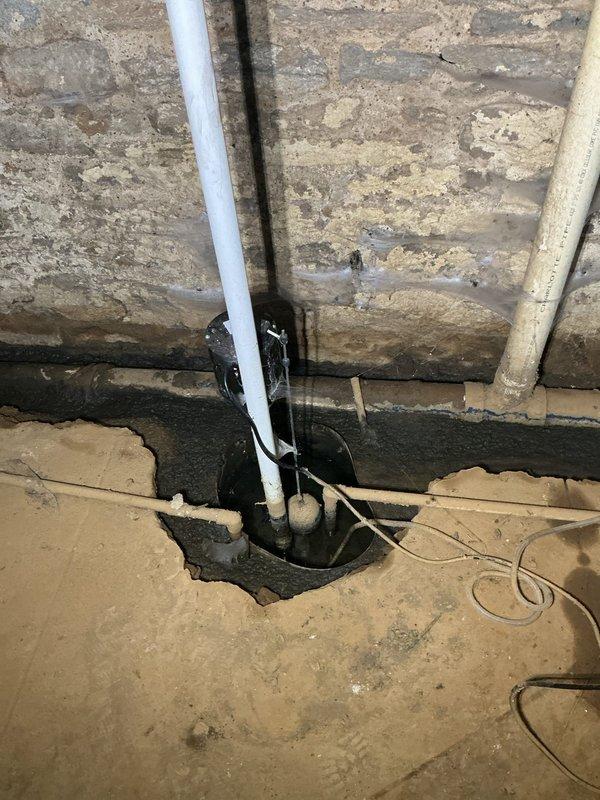 Responded to a main drain backup causing sump pump bubbling and water accumulation in the basement. Located the main cleanout approximately 10 feet from the affected area on the exterior wall and performed a complete drain cleanout to restore proper flow to the municipal sewer system. Successfully cleared the blockage, eliminating the backup condition and restoring normal drainage function throughout the system.