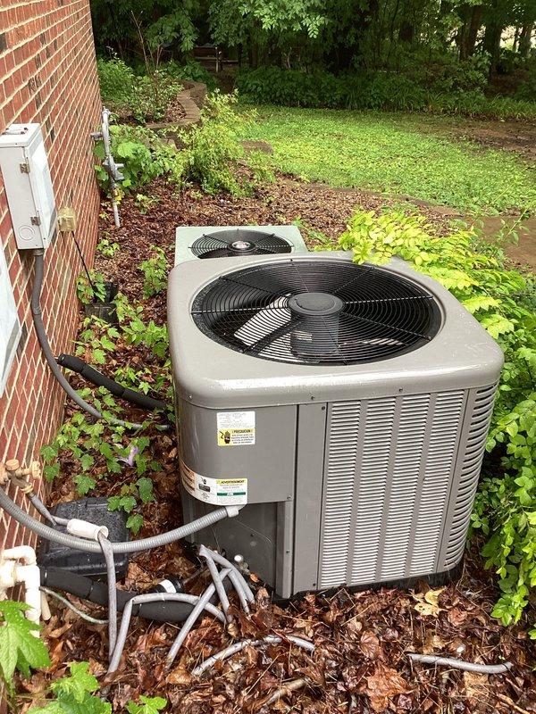 Responded to no-cooling complaint on upstairs HVAC system at residential property with dual condenser units. Upon arrival, confirmed 6-year-old system was not operating with no airflow at vents and no breakers tripped. Performed diagnostic evaluation of beige/tan condenser unit designated for upstairs zone, inspected electrical disconnect, refrigerant line connections, and verified system status against customer-reported symptoms of complete system failure.