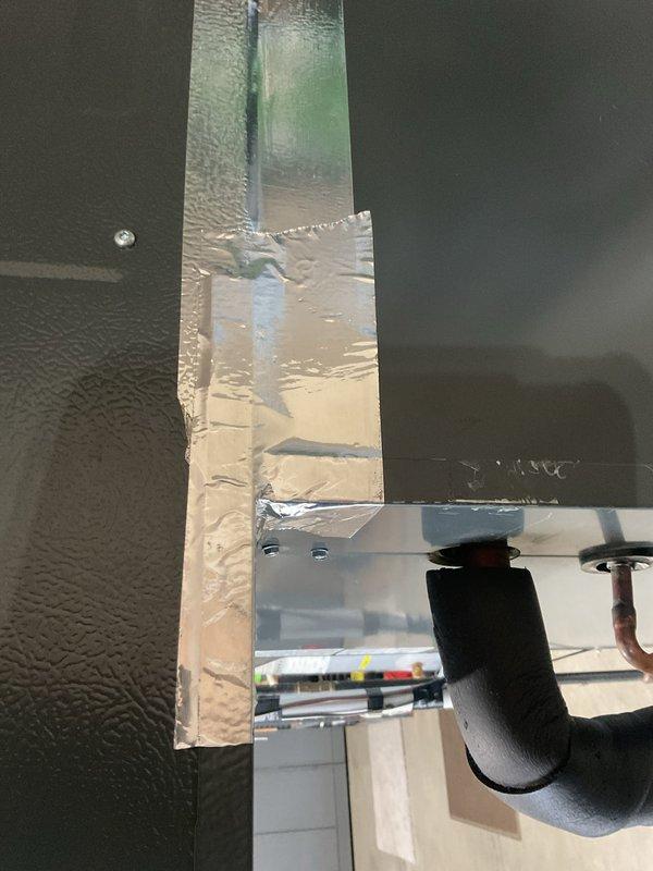 Responded to follow-up service call regarding incomplete planned maintenance from previous visit. Upon arrival, inspected HVAC ductwork in overhead space where previous technician had applied temporary sealant tape to seal duct opening. Found that foil tape had detached from duct chase opening, allowing conditioned air to escape into unconditioned garage space. Removed failed tape application and properly sealed rectangular duct opening with appropriate foil-faced tape, ensuring complete adhesion to all edges of the chase. Verified duct insulation integrity and confirmed no additional air leakage points in the overhead mechanical space. System now operating efficiently with conditioned air properly contained within the intended distribution system.