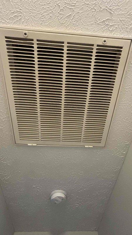 Completed comprehensive HVAC replacement estimate for aging but functional furnace and air conditioning system. Assessed existing downflow configuration, documented ceiling-mounted return air grille, evaluated base condition and floor-to-ceiling clearances, and provided technical specifications for complete system replacement including furnace, evaporator coil, and ductwork components.