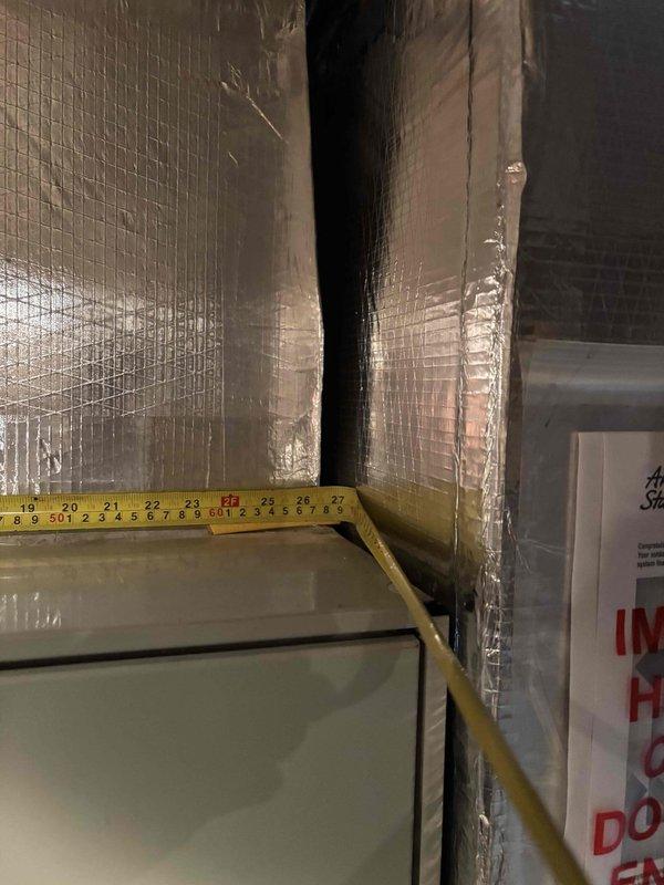 Responded to no cooling complaint on 16-20 year old American Standard air handler system. Upon arrival, confirmed unit was running with adequate airflow through vents but no cooling output. Performed diagnostic evaluation of the system including inspection of the air handler unit and associated ductwork in the mechanical space. Assessed refrigerant levels, electrical components, and overall system operation. Documented equipment condition with measurements and photographs of the installation, including foil-faced insulated ductwork and air handler cabinet. System showed typical age-related wear consistent with equipment in this service life range. Provided assessment findings and repair recommendations to address the no cooling condition.