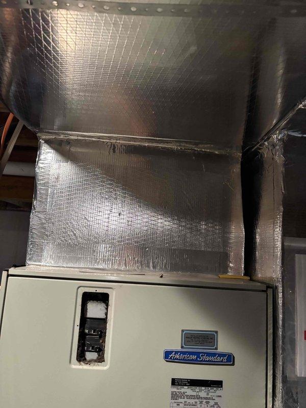 Responded to no cooling complaint on 16-20 year old American Standard air handler system. Upon arrival, confirmed unit was running with adequate airflow through vents but no cooling output. Performed diagnostic evaluation of the system including inspection of the air handler unit and associated ductwork in the mechanical space. Assessed refrigerant levels, electrical components, and overall system operation. Documented equipment condition with measurements and photographs of the installation, including foil-faced insulated ductwork and air handler cabinet. System showed typical age-related wear consistent with equipment in this service life range. Provided assessment findings and repair recommendations to address the no cooling condition.