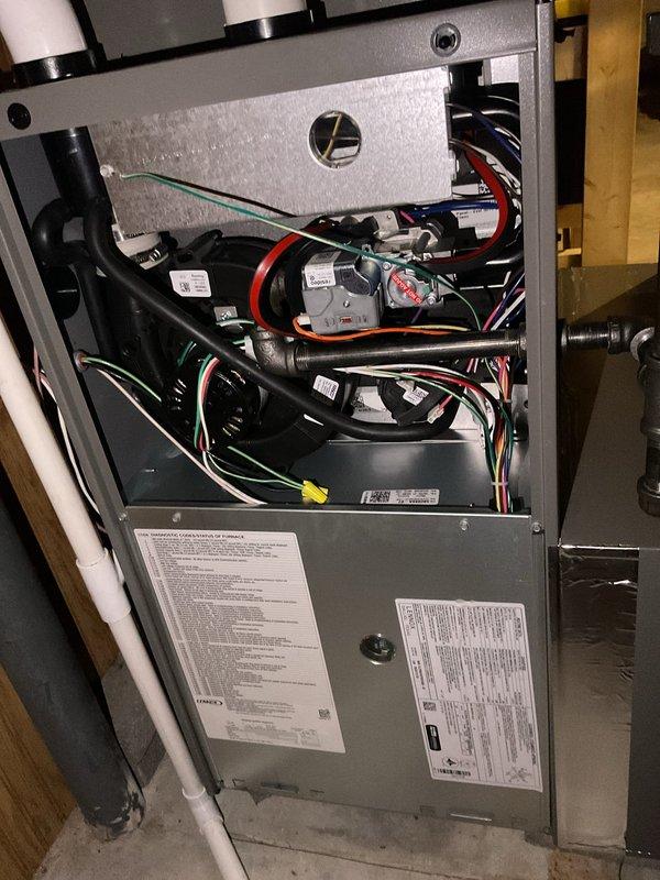 # HVAC Maintenance Service Summary

Completed annual planned maintenance inspection on residential forced-air furnace system as part of second visit under maintenance agreement. Performed comprehensive system evaluation including removal of access panels to inspect internal components, electrical connections, and control boards. Verified proper operation of blower motor assembly and examined all wire harnesses for secure connections and proper labeling. Inspected condensate drain lines and PVC venting system for proper installation and functionality.

Conducted electrical diagnostics using digital multimeter to verify voltage and amperage readings across control boards and electrical components. Examined three-tiered circuit board assembly within control panel, checking all connections, capacitors, resistors, and integrated circuits for proper operation. Verified all wire connections throughout the system including red, blue, yellow, white, black, and green wire runs. Confirmed all saf