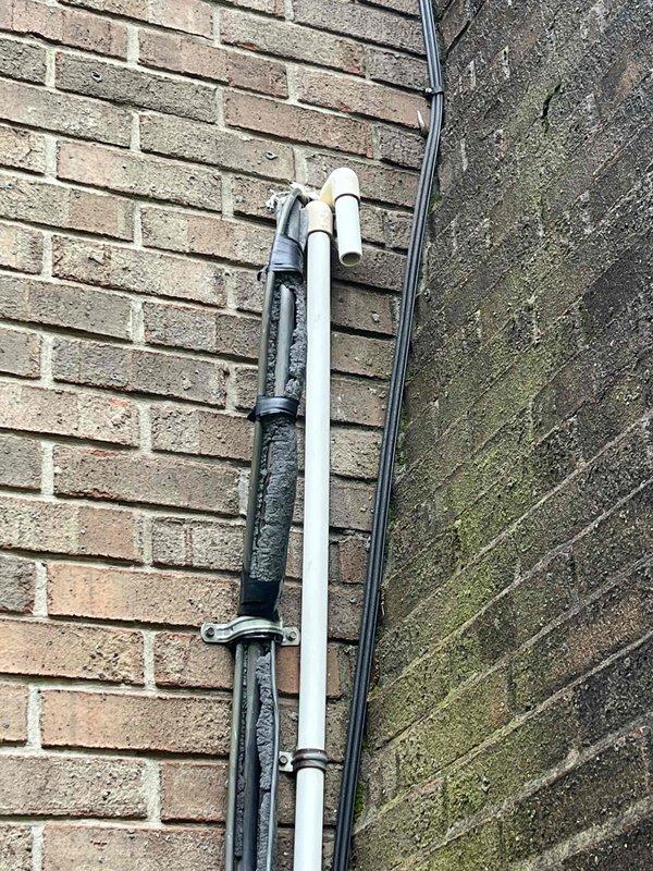 Completed comprehensive HVAC replacement estimate for residential system experiencing refrigerant leak. Evaluated existing air handler unit located in attic space and assessed exterior condensing unit with associated refrigerant lines and electrical conduit mounted to building exterior. Documented current system configuration including ductwork connections, condensate drainage, and electrical service to provide accurate replacement specifications and equipment sizing recommendations.