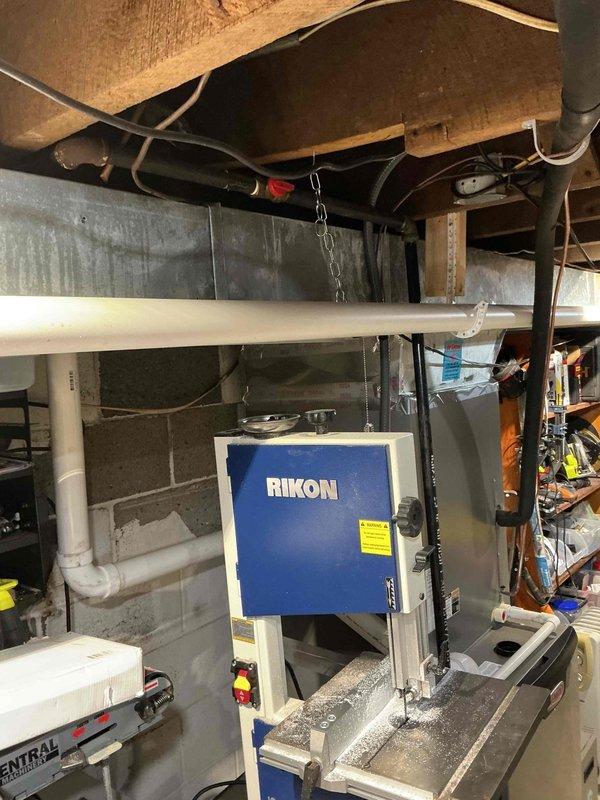 Conducted follow-up assessment for water heater replacement options in basement location. Evaluated existing mechanical infrastructure including current water heater installation located under stairs, plumbing supply and drainage lines, gas connections, and available space for upgraded equipment. Documented basement ceiling area showing existing PVC water supply lines with insulation, drainage piping, ductwork, and structural joists to determine routing requirements for new installation. Assessed utility room configuration with concrete block walls and existing mechanical equipment to verify clearances and ventilation requirements. Prepared comprehensive estimates for two replacement scenarios: traditional tank-style gas water heater and tankless gas water heater system, both sized appropriately for increased capacity needs. Recommendations include removal of current under-stairs unit and installation of larger capacity system in basement location with proper venting, gas line modifica