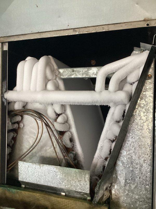 Responded to no-cooling complaint on 17-year-old residential air conditioning system. Upon arrival, found outdoor condensing unit inoperative with reported history of loud noise prior to failure. Indoor evaporator coil inspection revealed severe frost and ice accumulation on refrigerant lines and coil surfaces, indicating restricted airflow or refrigerant system malfunction. Outdoor unit showed signs of age with debris accumulation around base. Documented frozen evaporator coil condition and exterior unit status with photographic evidence. Advised system shutdown to allow complete defrost of indoor coil before further diagnostic work could be performed. Given the age of the equipment and severity of the failure, recommended comprehensive system evaluation once defrost is complete to determine root cause and feasibility of repair versus replacement options.
