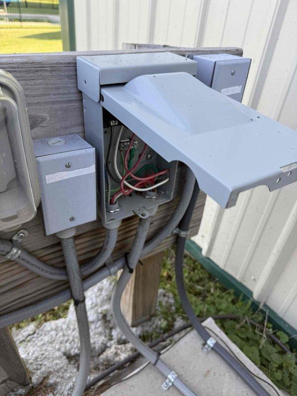 Responded to service call for pool pump switch estimate. Upon arrival, inspected existing outdoor electrical installation consisting of multiple junction boxes and disconnect mounted on exterior wall with associated conduit runs. Documented current configuration of electrical service setup including open disconnect box revealing internal wiring connections with multiple circuit conductors. Provided estimate for installation of flip switch control for pool pump operation based on existing electrical infrastructure and equipment accessibility.