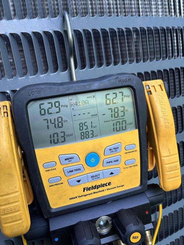 Responded to no cooling complaint on 5-year-old system that had received maintenance service in March. Performed diagnostic leak search using digital refrigerant manifold gauge, measuring system pressures at 629 psig high side and 627 psig low side with superheat reading of 74.8°F and subcooling at 103°F. Inspected evaporator coil assembly and refrigerant lines at indoor air handler unit, examining serpentine coil configuration and associated components for refrigerant loss or system deficiencies.