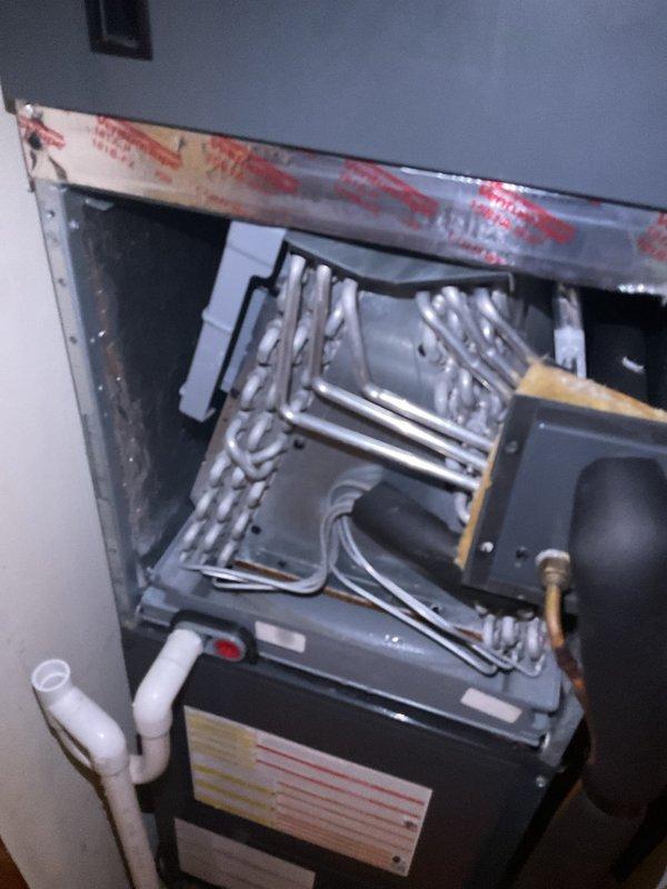 Responded to no cooling complaint on 5-year-old system that had received maintenance service in March. Performed diagnostic leak search using digital refrigerant manifold gauge, measuring system pressures at 629 psig high side and 627 psig low side with superheat reading of 74.8°F and subcooling at 103°F. Inspected evaporator coil assembly and refrigerant lines at indoor air handler unit, examining serpentine coil configuration and associated components for refrigerant loss or system deficiencies.
