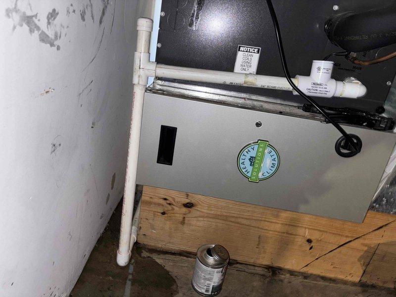 Responded to emergency water leak in basement affecting HVAC system. Upon arrival, found active water discharge from condensate drain line with significant water accumulation throughout basement area. Installed P-trap on condensate drain line to resolve leak and ensure proper drainage function. Performed routine maintenance on two-year-old system including replacement of 20x26x5 carbon filter. Verified all drain connections secured and system operating properly with no further water discharge. Documented equipment condition and installation with photographs.