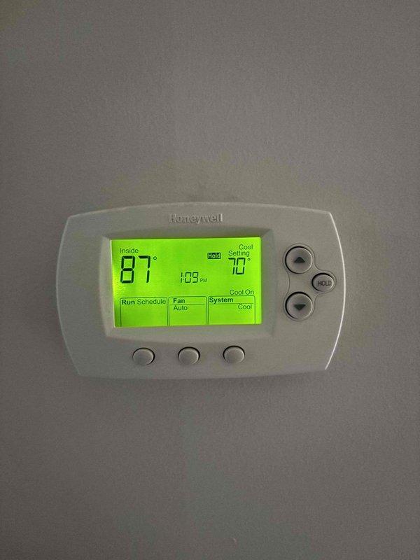 Responded to no-cool complaint on 4-year-old upstairs HVAC system that was completely inoperative. Upon arrival, thermostat displayed 87°F actual temperature with 77°F cooling setpoint in hold mode, indicating system failure to maintain desired temperature. Performed diagnostic evaluation of furnace and air handler components, inspecting blower motor assembly, electrical connections, wiring harnesses, and control boards. Verified no tripped breakers and confirmed proper power supply to unit. Identified system malfunction preventing compressor operation and restored cooling functionality to upstairs zone, returning system to normal operating parameters.