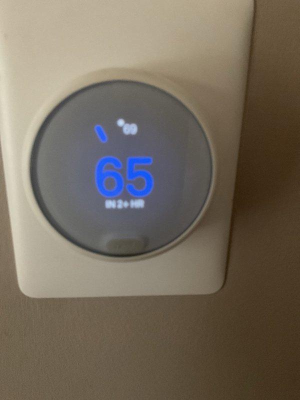 Responded to callback for HVAC system failure following previous service visit. Upon arrival, found outdoor condenser unit and indoor thermostat both operational at time of inspection. Thermostat display showing 65°F setpoint in heating mode with normal functionality. Condenser unit positioned against exterior lattice fence, sitting on concrete pad with protective top grille intact. System appeared to be cycling properly during diagnostic check. Documented equipment condition through photographs for service records. Customer reported system worked approximately one day after initial service call before experiencing repeated failure. Will require continued monitoring to identify intermittent issue causing system shutdown between service visits.
