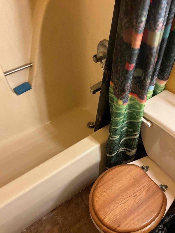 Conducted on-site assessment for bathroom conversion project to replace existing bathtub/shower combination with accessible walk-in shower unit. Evaluated current bathroom configuration including beige tiled tub surround, plumbing fixture locations, and existing drainage system. Documented measurements and photographed bathroom layout to determine scope of work including demolition of current tub, tile removal, potential plumbing modifications, and installation requirements for new walk-in shower system with appropriate waterproofing and accessibility features.