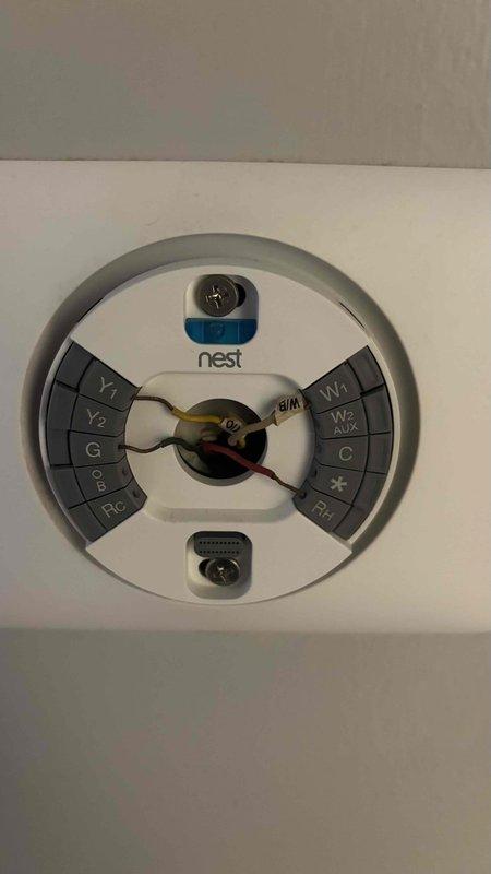 Responded to service call for non-functioning air conditioning system requiring replacement estimate and second opinion. Upon arrival, conducted thorough assessment of existing HVAC equipment and infrastructure. Inspected current thermostat installation, identifying Nest smart thermostat with multi-stage system wiring including Y1, Y2, G, OB, RC, W1, W2, C, and RH terminals properly connected. Evaluated existing ductwork connections and condensate drain line configuration in mechanical space. Documented equipment clearances and measured available installation space for replacement system sizing considerations. Photographed thermostat wiring configuration to ensure proper compatibility with replacement equipment specifications. Assessed mechanical room layout and existing pipe connections to determine optimal replacement unit positioning. Reviewed system requirements and discussed replacement options with homeowner based on current equipment failure and home comfort needs. Provided prof