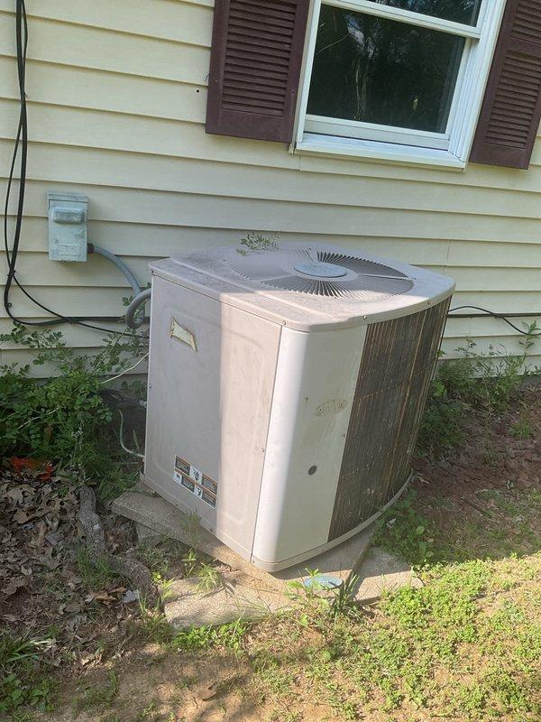 Evaluated 30-year-old outdoor air conditioning condenser unit for replacement. Unit showed significant weathering, discoloration, and dirt accumulation consistent with age and extended outdoor exposure. Documented existing equipment condition including internal electrical connections, wiring harness, refrigerant lines, and mounting components. Photographed exterior cabinet condition and internal component layout to support replacement estimate.