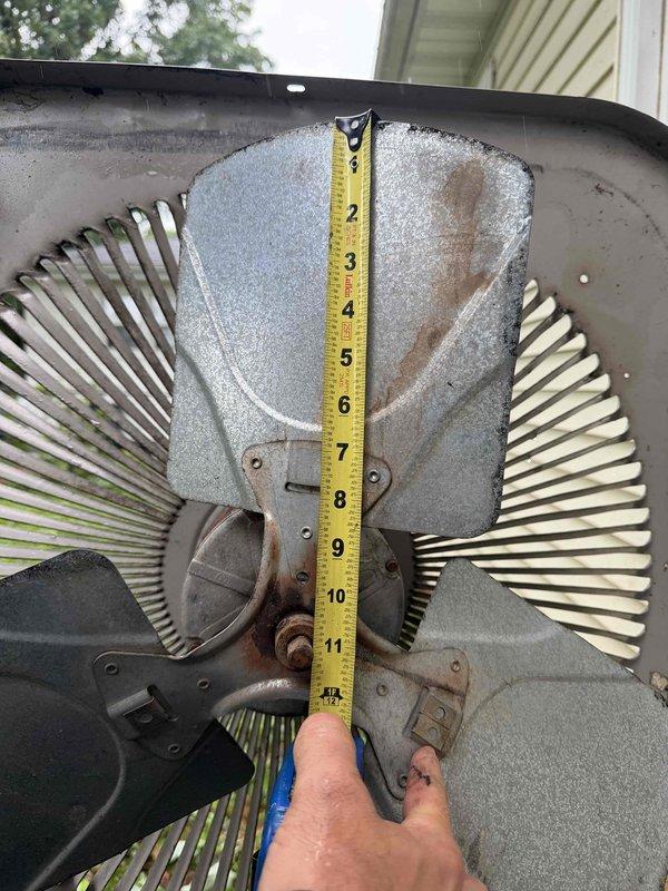 Responded to no cooling complaint with no airflow through vents. Upon inspection, diagnosed failed condenser fan motor blade preventing proper air circulation through the outdoor unit. Documented fan blade dimensions and condition with measurements for accurate replacement part ordering. System age undetermined but estimated under 10 years based on property information. Unit currently inoperable and requires follow-up appointment to install replacement fan blade under warranty coverage, with estimated repair time of one hour once part arrives.