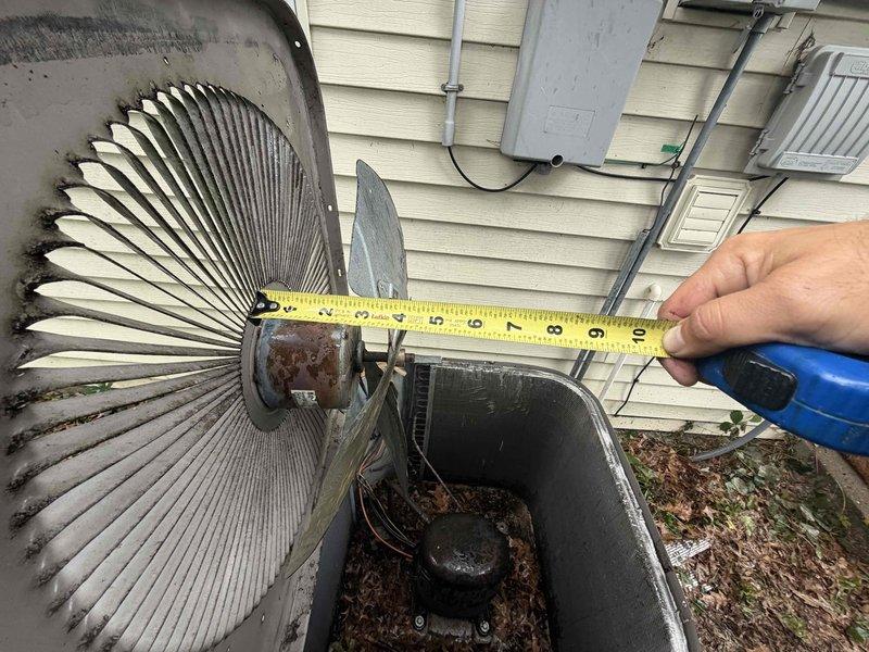 Responded to no cooling complaint with no airflow through vents. Upon inspection, diagnosed failed condenser fan motor blade preventing proper air circulation through the outdoor unit. Documented fan blade dimensions and condition with measurements for accurate replacement part ordering. System age undetermined but estimated under 10 years based on property information. Unit currently inoperable and requires follow-up appointment to install replacement fan blade under warranty coverage, with estimated repair time of one hour once part arrives.