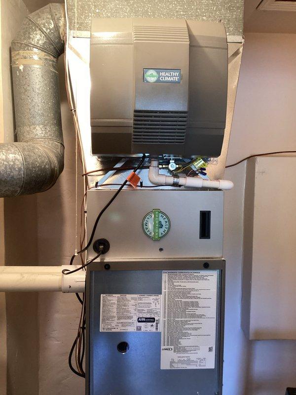 Successfully installed a Healthy Climate power humidifier unit integrated with the existing HVAC system. The humidifier was properly mounted atop the furnace assembly, with all electrical connections completed and wiring secured according to manufacturer specifications. The installation included routing and connecting the water supply line, establishing proper ductwork integration with the existing metallic flex duct, and verifying all control settings on the humidistat for optimal operation.