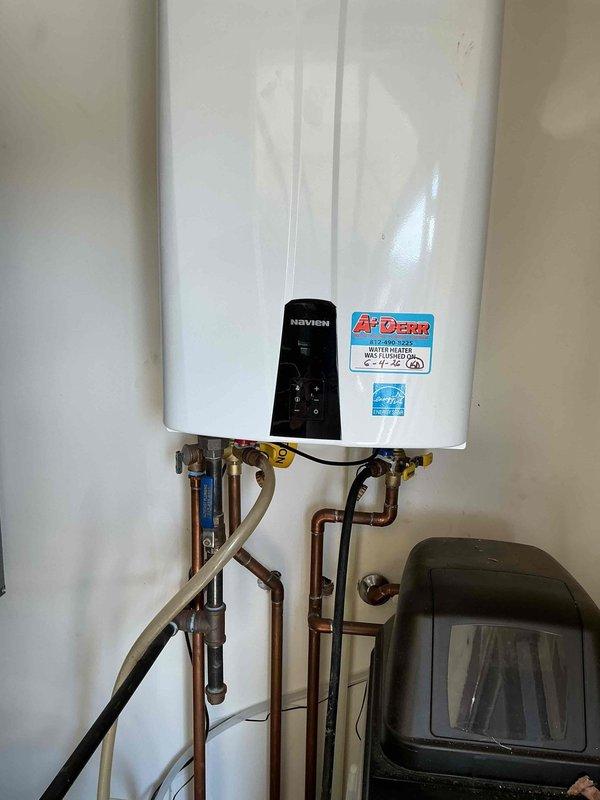 Performed USA Bronze preventive maintenance service on Navien tankless water heater unit. Completed full system flush procedure to remove mineral buildup and scale deposits from heat exchanger, descaled internal components using appropriate cleaning solution, and verified proper operation of all valves and connections. Unit tested and confirmed operating within manufacturer specifications upon completion of maintenance service.